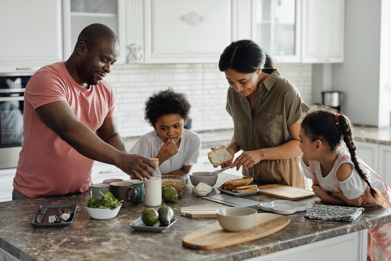 a family making breakfast with bread and avocados
